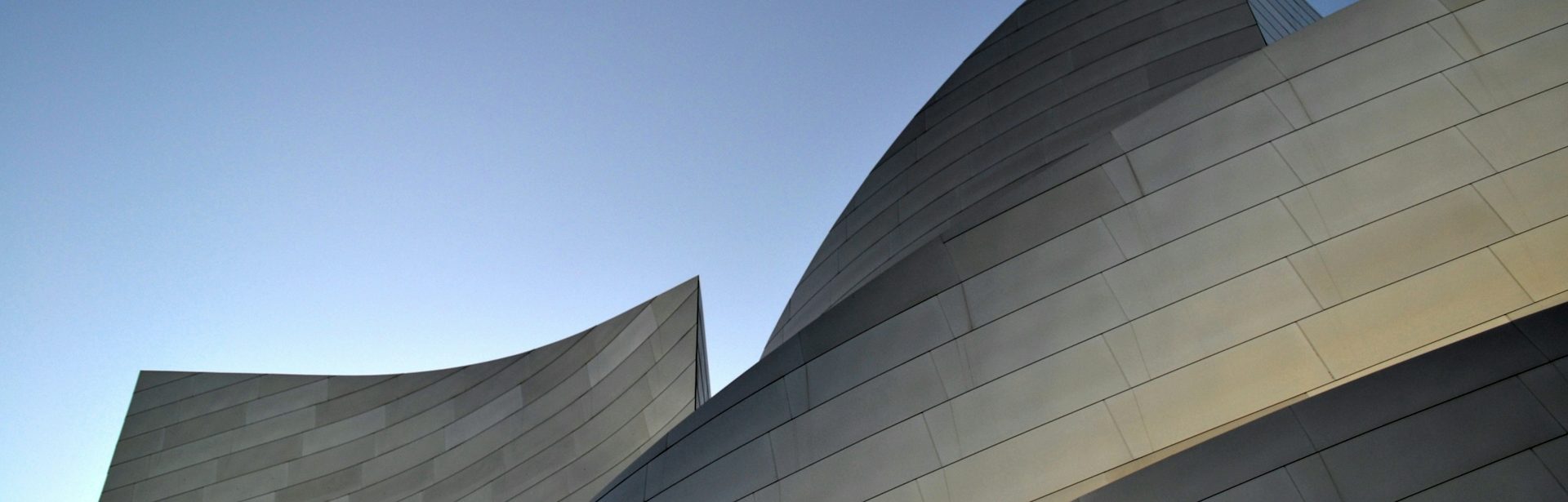 Curved architectural structures against a clear blue sky.